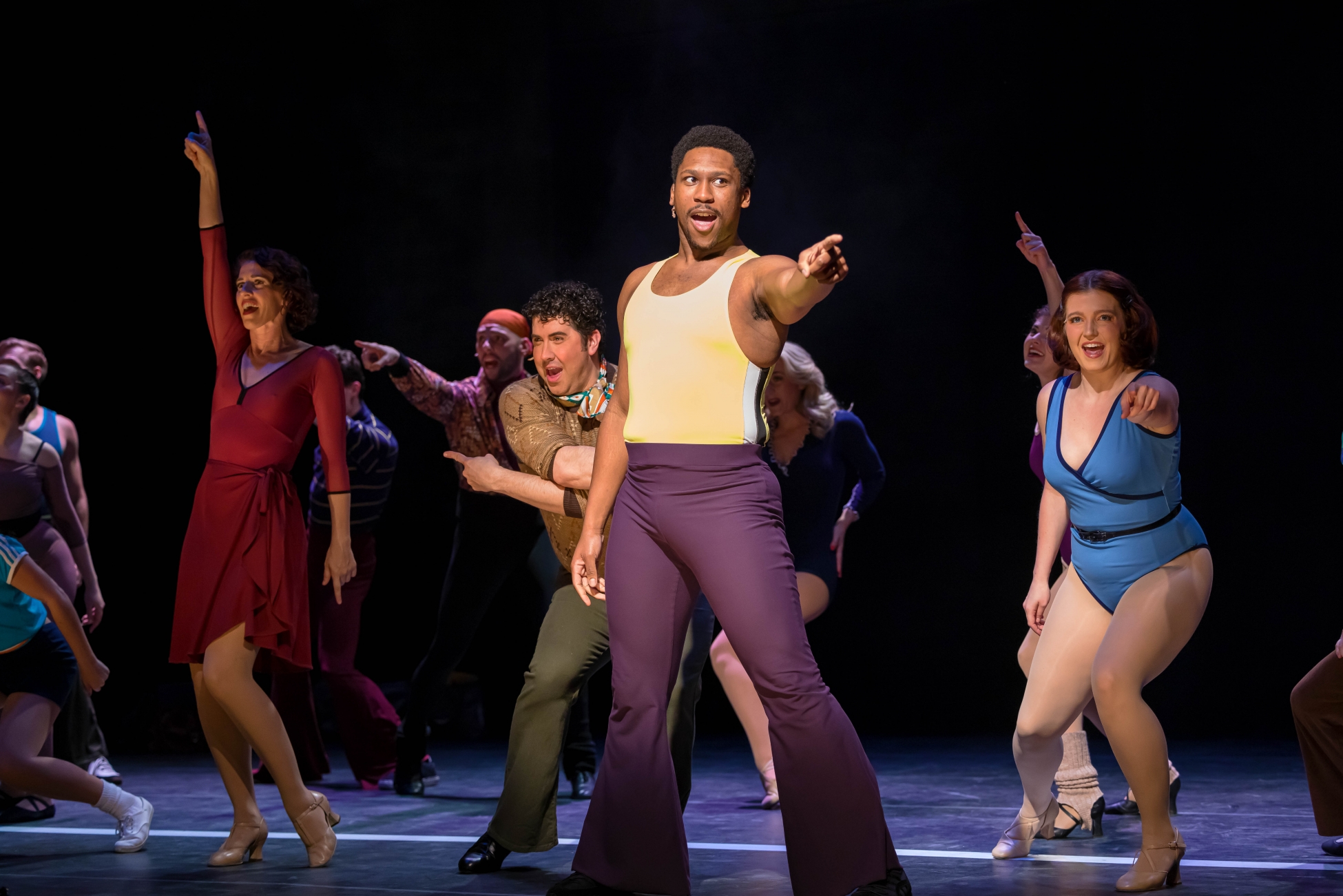 Michael Charles as Richie and several other auditioners in A Chorus Line point.