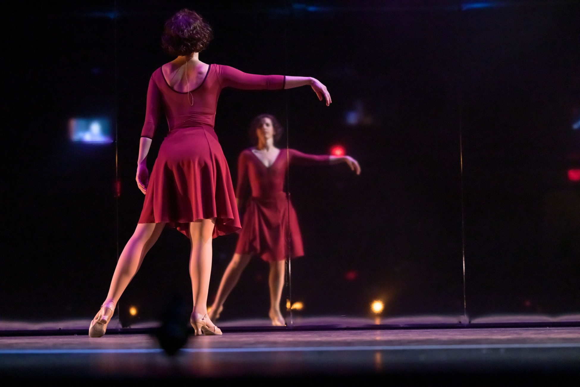 Sarah Wiechman as Cassie in A Chorus Line stares at a mirror and sways her arm.
