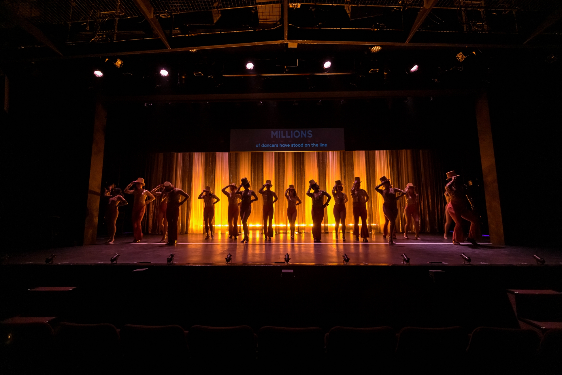 Dancers in A Chorus Line strike a final pose, the lights dim on them.