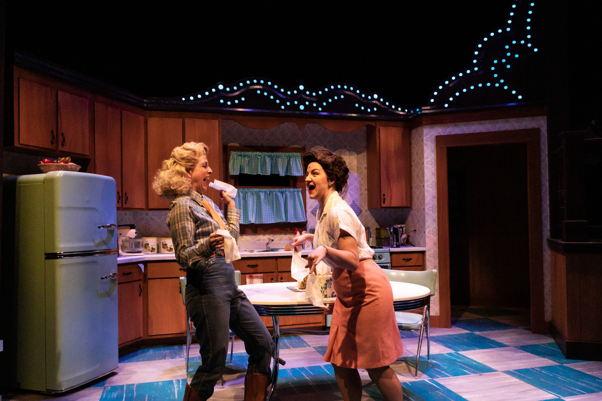 Cassie Chilton as Patsy Cline and Katie McFadzen as Louise dancing together in a kitchen.
