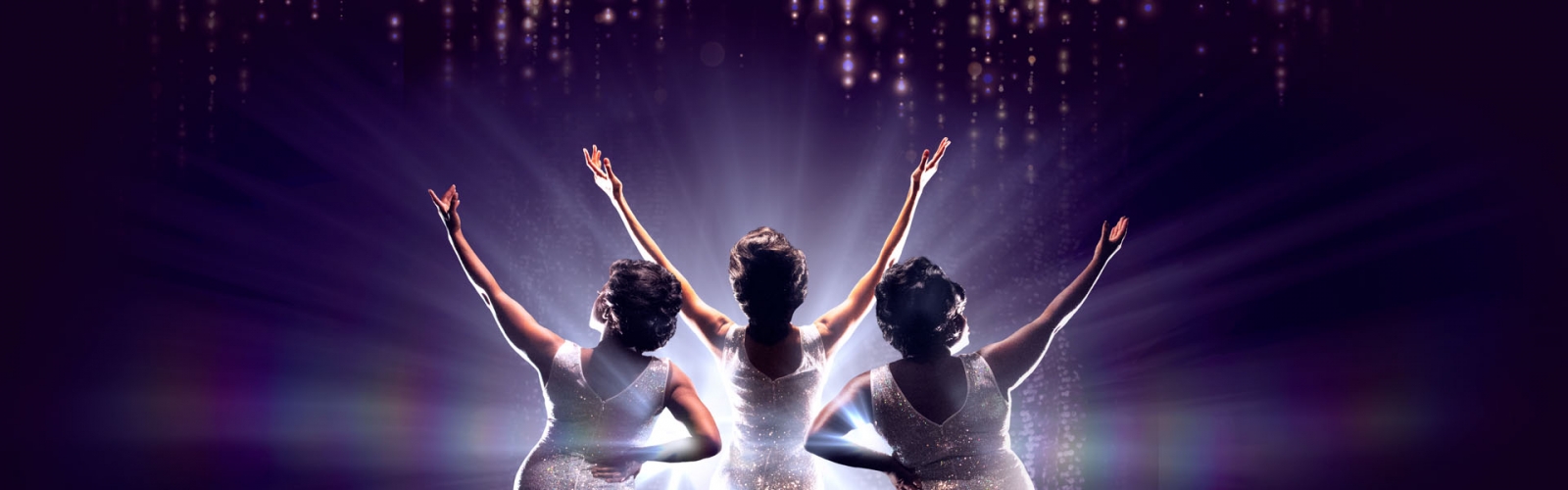 Three women with their backs turned, hands up in a V, in sequin dresses
