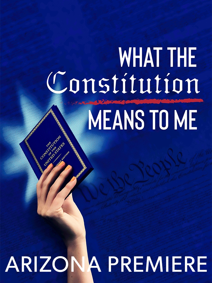 A woman holds a blue pocket sized version of The Constiution of the United States